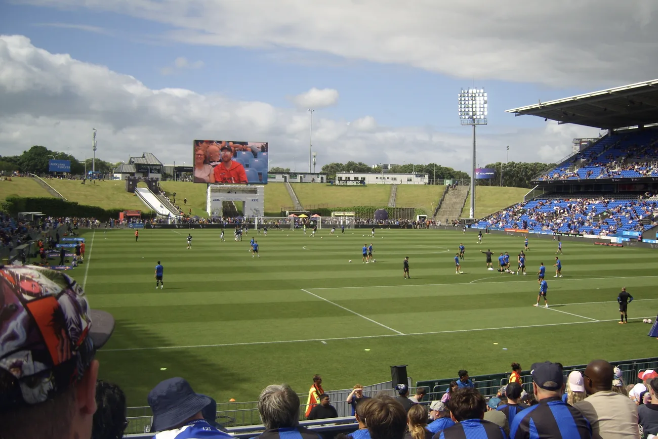 A packed football stadium on a sunny day