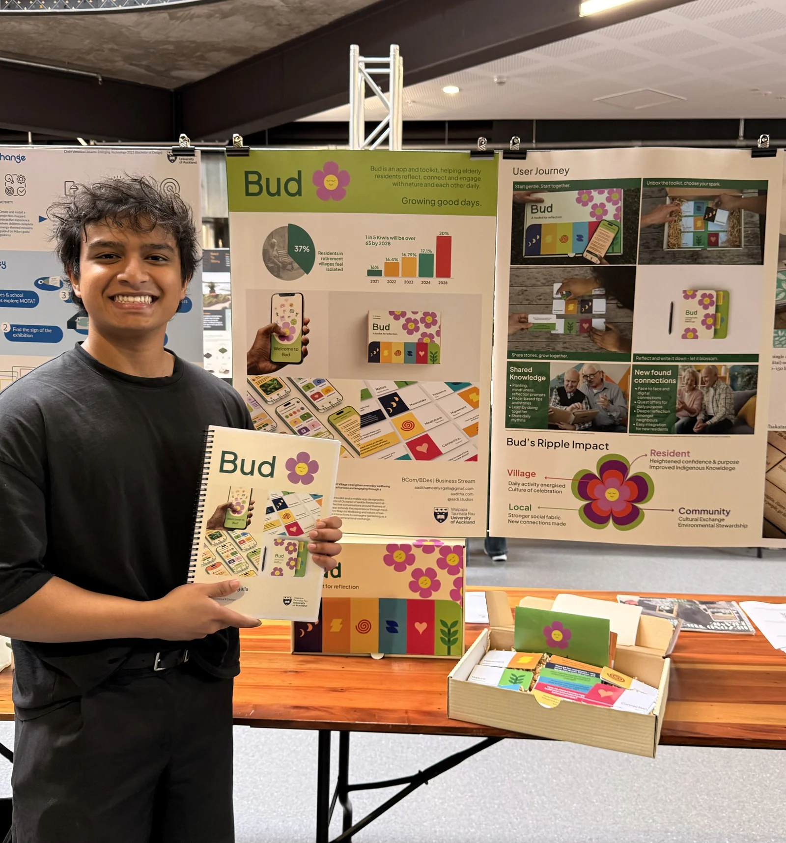 Aaditha at the capstone exhibition with the finished Bud — posters, facilitator booklet, box and reflection cards on the table